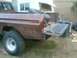 1976 Ford F-250 - The rear of a brown 1973 Ford F-Series pickup truck is shown with its tailgate down, revealing a spare tire in the bed.