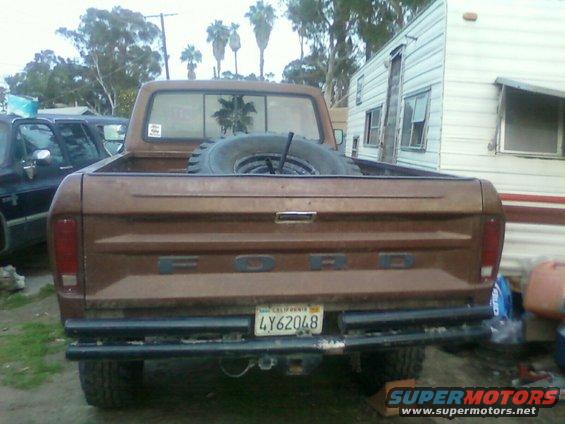 Brown 1976 Ford F-250 pickup truck rear view with spare tire in bed