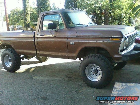 Brown 1973 Ford F-250 pickup truck with lifted suspension and large tires, viewed from the side