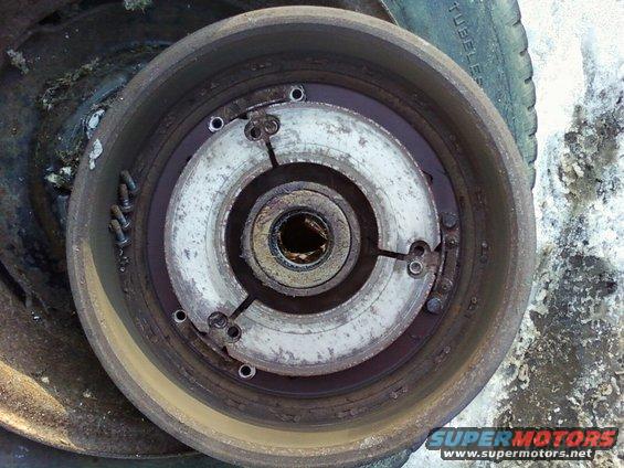 close-up of a rusty vehicle brake drum with visible wear and bolts