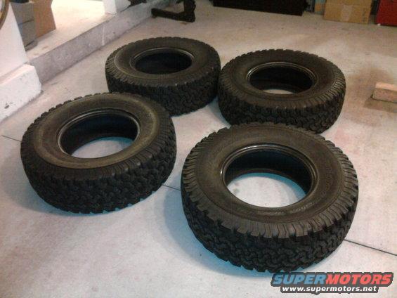 Four off-road tires on a concrete floor