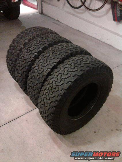four BFGoodrich All-Terrain T/A tires stacked in a garage