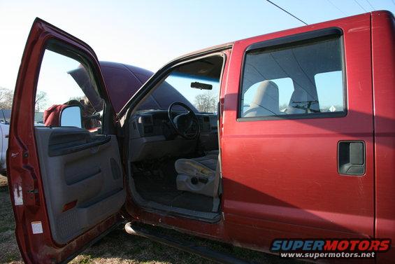 red pickup truck with driver's door and hood open, showing interior