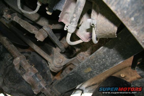 Close-up of rusty steering linkage and suspension parts under a vehicle