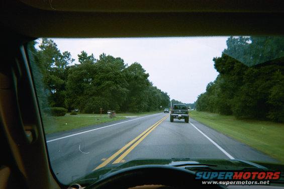 Rear view of black pickup truck on a rural road
