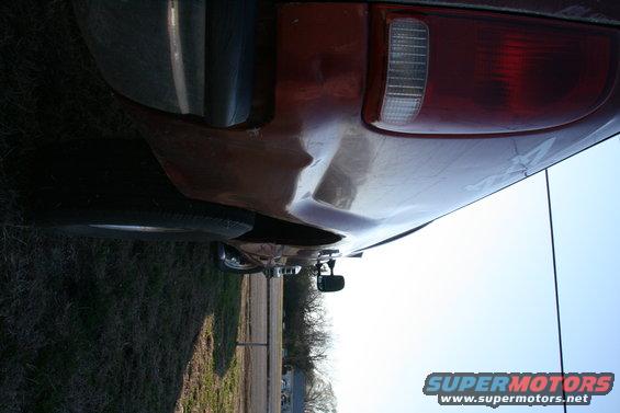 Rear quarter panel with dent and taillight of a pickup truck