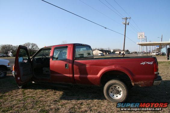 Red pickup truck with 4x4 decal, driver's door open