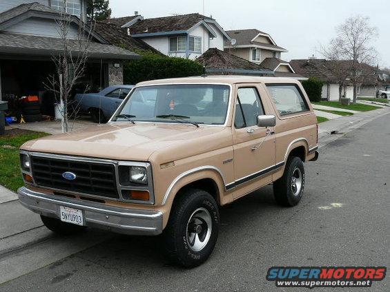 Tan Ford Bronco parked on a residential street, front quarter view. License plate is 5NYU903
