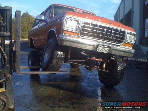 1978 Ford Bronco with lifted suspension, front end on forklift forks. License plate 6FJC776