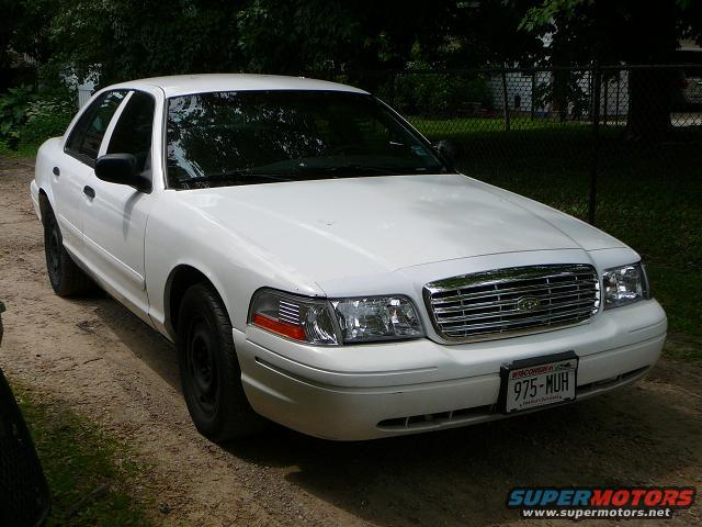 White 2003 Ford Crown Victoria 3q-front view with chrome grille and license plate 975-MUH