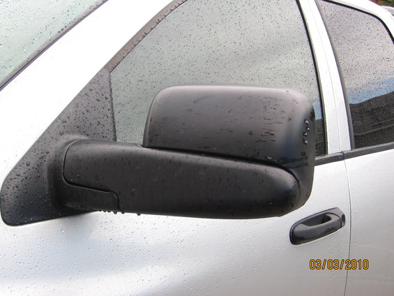 White truck with black side mirror covered in water droplets. Date stamp 03/03/2010 visible