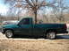 1995 GMC Sierra 1500 - A side view of a green 1995 GMC Sierra 1500 pickup truck parked outdoors.