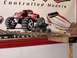 1993 Suzuki Sidekick - RC monster trucks and a boat graphic are displayed on a shelf with a wooden track.