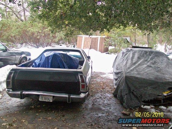 Rear view of a 1973 Ford Ranchero with a tarp in the bed and a license plate reading 7E38343