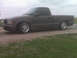 1998 GMC Sonoma - A dark pickup truck is parked on a concrete pad with grass in the foreground.