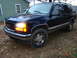 1999 GMC Yukon - This SUV is parked outside on a cloudy day with fallen leaves on the ground.