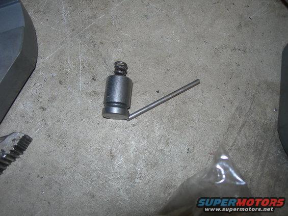 Metal part with a spring-loaded plunger and a thin rod attached