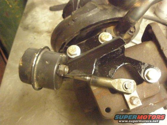 Close-up of a turbocharger wastegate actuator with a linkage connected to a bracket