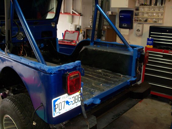 Blue 1978 Jeep CJ5 rear view, Florida license plate P07 386, in a garage with tools and a toolbox