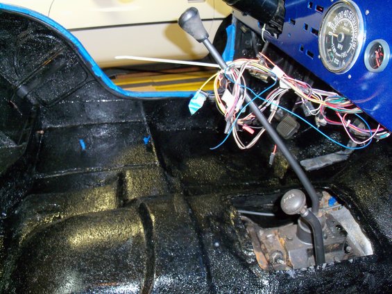 Jeep interior showing floor, dashboard wiring, and gear shifters