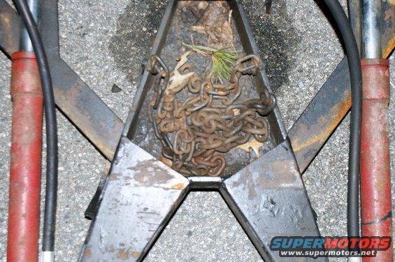 Trailer hitch assembly with rusty chains inside a metal receptacle