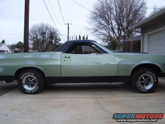 Light green 1972 Ford Ranchero pickup truck, side view, with a black vinyl roof and aftermarket wheels