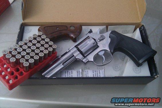 Revolver with wooden and black grips, box of bullets, and desiccant packets inside a box