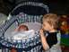 1984 Ford Bronco - A toddler observes a newborn baby sleeping in a bassinet, with a toy horse in the background.