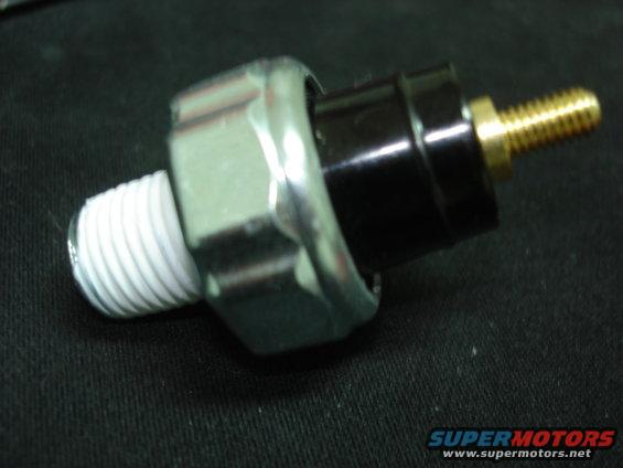 Oil pressure sensor with metal hex fitting and black plastic body, threaded end with white sealant