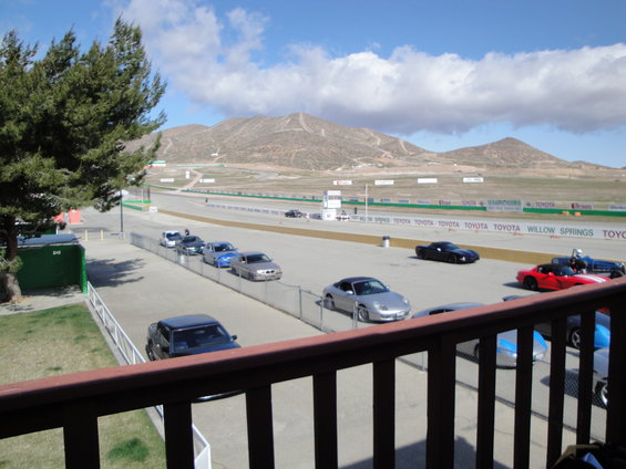 Cars lined up on a race track with mountains in the background