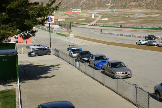 Cars lined up on a race track with mountains in the background. Toyota signage visible
