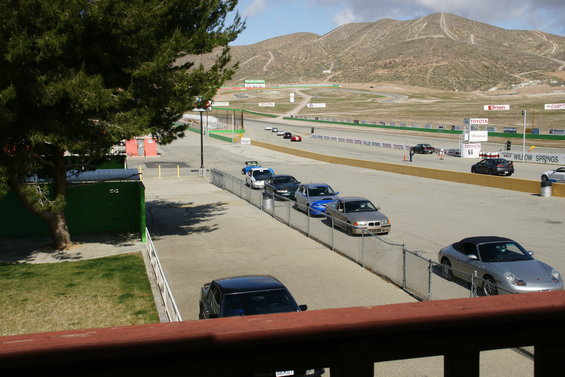 Cars lined up on a race track with mountains in the background