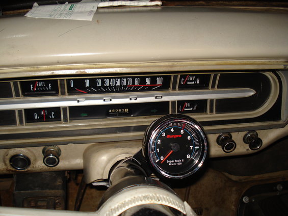 1967 Ford F-250 dashboard with fuel, temperature, oil gauges, and an aftermarket tachometer