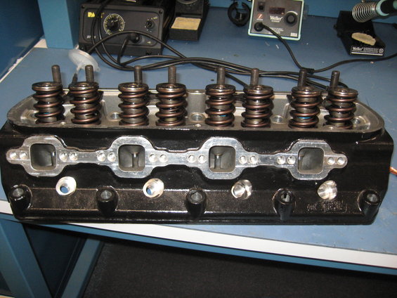 Engine cylinder head with valve springs and intake ports