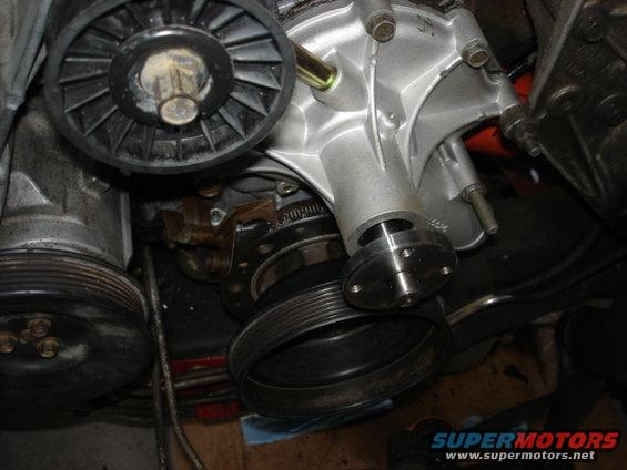 Close-up of a car's engine water pump and pulley system