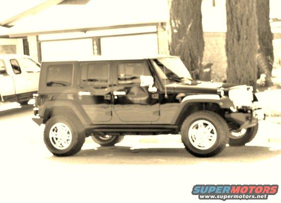 Black Jeep Wrangler 4-door parked on asphalt
