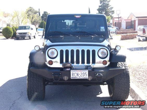 Front view of black Jeep Wrangler with aftermarket bumper and winch. License plate reads RCN 205