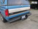 1993 Ford F-250 - This blue Ford pickup truck is shown from the rear, a camper shell and a 'Turbo' badge.