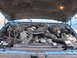1993 Ford F-250 - The engine bay of a blue 1993 Ford F-250 is visible with the hood raised, revealing the turbo diesel engine and associated components.