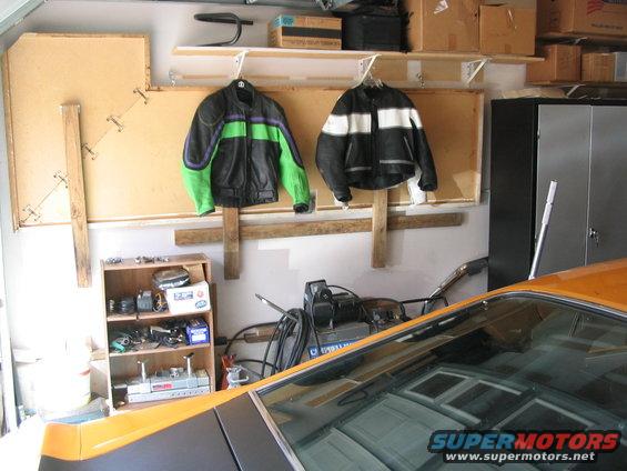 Orange car interior with motorcycle jackets and parts in garage