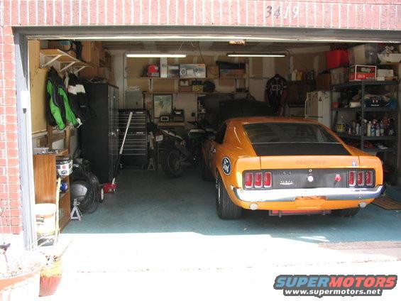 Orange 1970 Ford Mustang parked in a garage, rear view