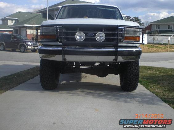 White 1995 Ford Bronco with a brush guard and aftermarket wheels parked on a driveway