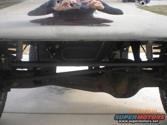 Undercarriage view of a lifted truck's front axle and suspension components