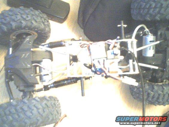 remote control car chassis with exposed wiring, motor, and suspension components