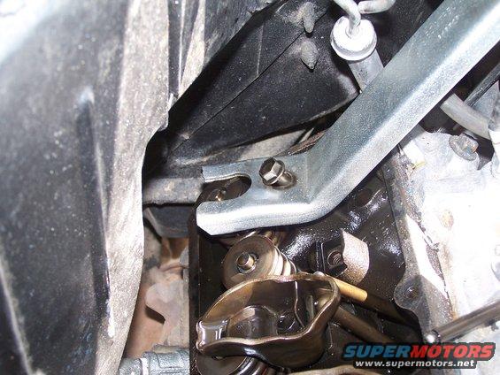 Close-up of engine valve train parts, including rocker arms and springs, with oil visible