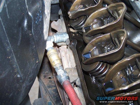 Engine valve train with air hose connected to cylinder head