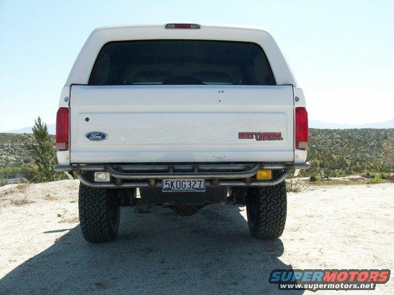 Rear view of a white 1996 Ford Bronco with a custom bumper and off-road tires
