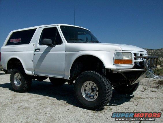 White 1996 Ford Bronco with aftermarket bumper and off-road tires