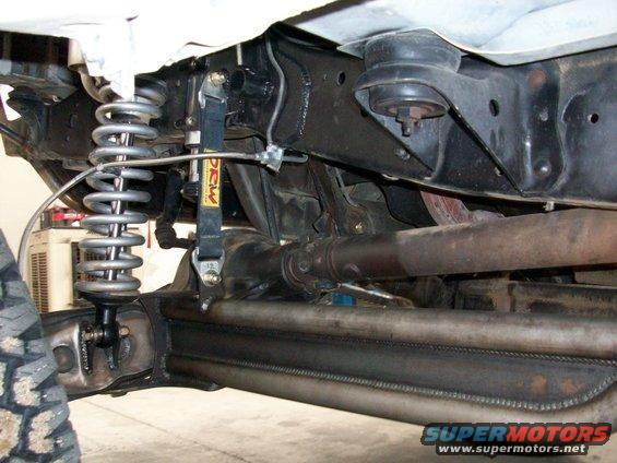 Close-up of modified suspension with large coilover and driveshaft