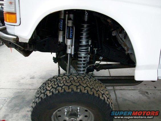 White 1996 Ford Bronco front suspension with Fox shocks and large tire